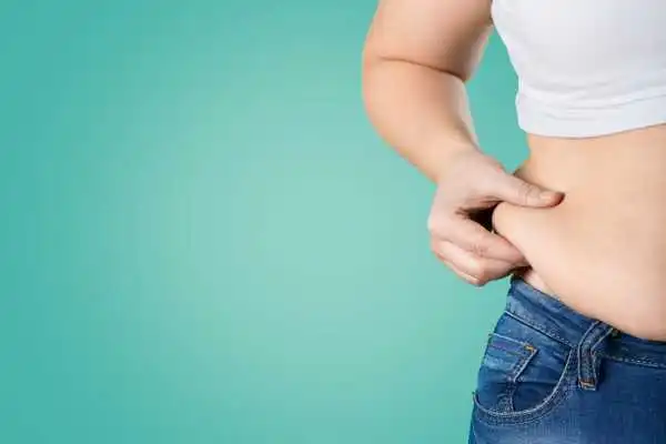 Image of woman pinching her love handles to show weight gain Kings Norton